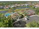 Community amenities: a pool, tennis courts, and clubhouse surrounded by lush landscaping and waterways at 490 Pine Lily Way, Venice, FL 34293