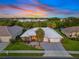 Stunning aerial view of the property showcasing its white roof, three car garage and landscaped surroundings at 490 Pine Lily Way, Venice, FL 34293