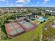 Community aerial view with tennis courts, pool, landscaping, and parking, offering recreational options at 490 Pine Lily Way, Venice, FL 34293