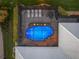Aerial view of enclosed pool area with lush landscaping and sun shelf at 490 Pine Lily Way, Venice, FL 34293