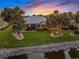 Waterfront backyard boasts mature palms and scenic water views, perfect for relaxation and entertainment at 490 Pine Lily Way, Venice, FL 34293