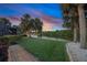 Gorgeous waterfront backyard with lush lawn and tropical landscaping for serene outdoor living at 490 Pine Lily Way, Venice, FL 34293