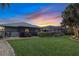 Spacious backyard featuring a screened lanai, verdant lawn, and well-manicured landscaping for outdoor enjoyment at 490 Pine Lily Way, Venice, FL 34293