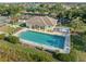 Aerial view of the community pool and amenity center with lush landscaping and comfortable seating at 490 Pine Lily Way, Venice, FL 34293