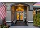 Inviting entryway featuring double doors with decorative wreaths, bench, and beautiful stonework at 490 Pine Lily Way, Venice, FL 34293