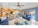 Spacious living room featuring stylish furnishings, ceiling fan, and kitchen access at 490 Pine Lily Way, Venice, FL 34293