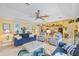 Open living room featuring bright, sunny decor, ceiling fan, and kitchen view at 490 Pine Lily Way, Venice, FL 34293