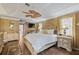 Spacious main bedroom featuring wood floors, a ceiling fan and decorative furniture at 490 Pine Lily Way, Venice, FL 34293