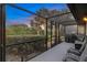 Enclosed patio with outdoor seating and grill overlooking lush landscaping at 490 Pine Lily Way, Venice, FL 34293