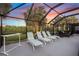 Enclosed pool area features lounge chairs, outdoor dining and views of lush landscaping at 490 Pine Lily Way, Venice, FL 34293