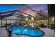 Enclosed pool area features sun shelf, lush landscaping, lounge chairs and dining area at 490 Pine Lily Way, Venice, FL 34293
