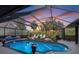 Enclosed pool area with lounge chairs, lush landscaping and sun shelf offers a relaxing outdoor retreat at 490 Pine Lily Way, Venice, FL 34293