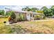 Exterior view of home with a small front porch surrounded by greenery and palm trees at 4922 18Th E St, Bradenton, FL 34203