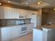 Bright kitchen featuring white cabinetry, modern appliances, and granite countertops at 5330 Hyland Hills Ave # 2314, Sarasota, FL 34241