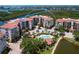 An aerial view of the condo complex featuring a pool, lush landscaping, and waterfront views at 5430 Eagles Point Cir # 101, Sarasota, FL 34231