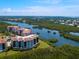 Stunning aerial view of waterfront condos surrounded by lush greenery and waterways under a sunny sky at 5430 Eagles Point Cir # 101, Sarasota, FL 34231