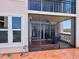 View of the outdoor balcony with a screened enclosure, featuring a table with seating at 5430 Eagles Point Cir # 101, Sarasota, FL 34231