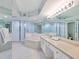 Bright bathroom featuring a large soaking tub, glass-enclosed shower, and a spacious vanity with ample counter space at 5430 Eagles Point Cir # 101, Sarasota, FL 34231