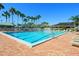 Large community pool with brick deck, clear blue water, lounge chairs, and a view of surrounding palm trees at 5430 Eagles Point Cir # 101, Sarasota, FL 34231