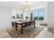 Open dining room with modern chandelier, wood table and chairs, and nice water view at 5430 Eagles Point Cir # 101, Sarasota, FL 34231