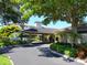 Community entrance with covered drop-off and landscaping at 5430 Eagles Point Cir # 101, Sarasota, FL 34231