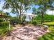 Outdoor grill area surrounded by lush landscaping, trees and a pond at 5430 Eagles Point Cir # 101, Sarasota, FL 34231