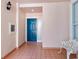 Hallway view featuring a blue door, neutral paint, tile floors, and a bench at 5430 Eagles Point Cir # 101, Sarasota, FL 34231