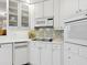Kitchen details featuring white cabinets and stainless appliances with decorative tile backsplash at 5430 Eagles Point Cir # 101, Sarasota, FL 34231