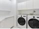 Bright laundry room featuring a modern washer and dryer, countertops, and storage cabinets at 5430 Eagles Point Cir # 101, Sarasota, FL 34231