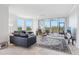 Bright and open living area featuring large windows, a comfortable sofa, and access to a balcony at 5430 Eagles Point Cir # 101, Sarasota, FL 34231