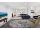 Open living room with tile flooring, oriental rug, modern furnishings, and view to dining room at 5430 Eagles Point Cir # 101, Sarasota, FL 34231