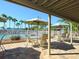 Shaded patio with tables and chairs overlooking the community pool surrounded by palm trees at 5430 Eagles Point Cir # 101, Sarasota, FL 34231