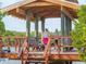 Wooden pavilion overlooking the water surrounded by lush foliage with benches and seating at 5430 Eagles Point Cir # 101, Sarasota, FL 34231