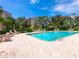 Relaxing pool area with lounge chairs and palm trees, surrounded by a brick patio and multi-story buildings at 5430 Eagles Point Cir # 101, Sarasota, FL 34231