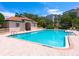 Inviting pool with clear blue water, surrounded by a brick patio and a cabana, perfect for summer days at 5430 Eagles Point Cir # 101, Sarasota, FL 34231