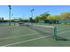 Exterior shot of community tennis courts showing net in the foreground and canopy covered picnic area in the background at 5430 Eagles Point Cir # 101, Sarasota, FL 34231