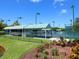 Exterior shot of community tennis courts with striped canopy covered picnic area and meticulously manicured landscaping at 5430 Eagles Point Cir # 101, Sarasota, FL 34231