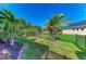 Backyard features a manicured lawn, mature landscaping, black aluminum fencing and curbing at 5439 74Th E Pl, Ellenton, FL 34222