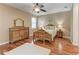 Bright bedroom with wood floors, ceiling fan, plantation shutters, and wooden furniture at 5439 74Th E Pl, Ellenton, FL 34222