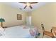 Bedroom with a ceiling fan, light-colored walls, carpeted floor, and a bed with colorful bedspread at 5439 74Th E Pl, Ellenton, FL 34222