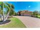 Charming home showcasing a well-manicured lawn, lush landscaping, and a paver driveway at 5439 74Th E Pl, Ellenton, FL 34222