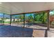 Covered patio featuring a hot tub, brick pavers, and screened enclosure with view of mature landscaping and palms at 5439 74Th E Pl, Ellenton, FL 34222
