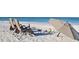 Relaxing beach scene featuring beach chairs, umbrella, and beach toys on white sand at 5522 Calle Del Verano, Sarasota, FL 34242