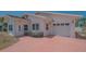 Paver driveway leading to a single-car garage and covered entry of the light colored home at 5522 Calle Del Verano, Sarasota, FL 34242