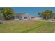 Exterior side view of a white house with a red brick driveway and mature tropical landscaping at 5522 Calle Del Verano, Sarasota, FL 34242