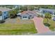 Exterior of house with a red brick driveway and mature landscaping is presented in a side-angle view at 5522 Calle Del Verano, Sarasota, FL 34242