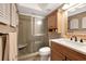 Bathroom featuring a single vanity, mirror, medicine cabinet, and tiled walk-in shower at 600 Manatee Ave # 143, Holmes Beach, FL 34217