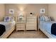 Bright bedroom with two twin beds, dressers, a bedside table, and tile floor at 600 Manatee Ave # 143, Holmes Beach, FL 34217