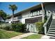 Charming condo exterior with lush landscaping, secure gate, and inviting stairs at 600 Manatee Ave # 143, Holmes Beach, FL 34217