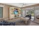 Cozy living room features a ceiling fan, entertainment center, and a sliding glass door to outdoor space at 600 Manatee Ave # 143, Holmes Beach, FL 34217